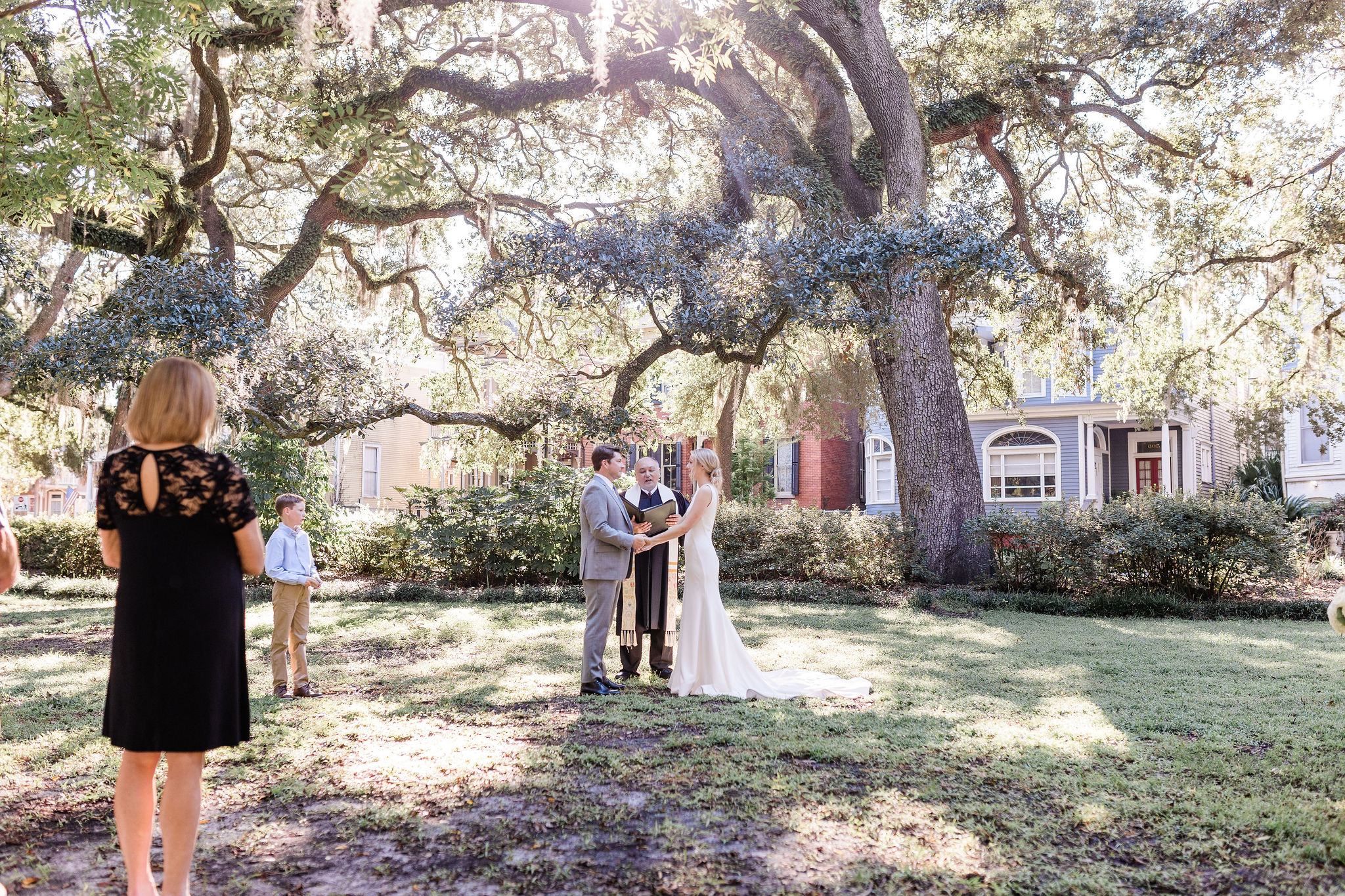 a couple getting married under a large tree.