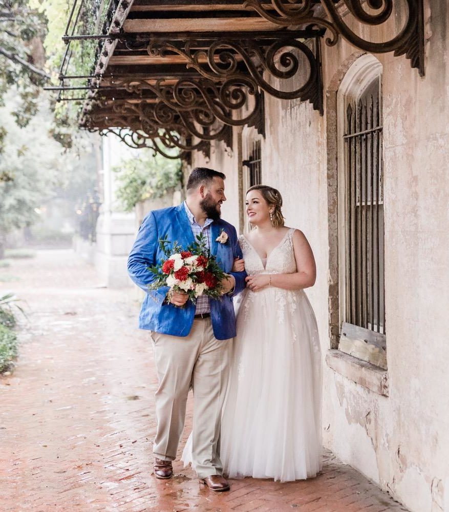 a bride and groom standing outside of a building.