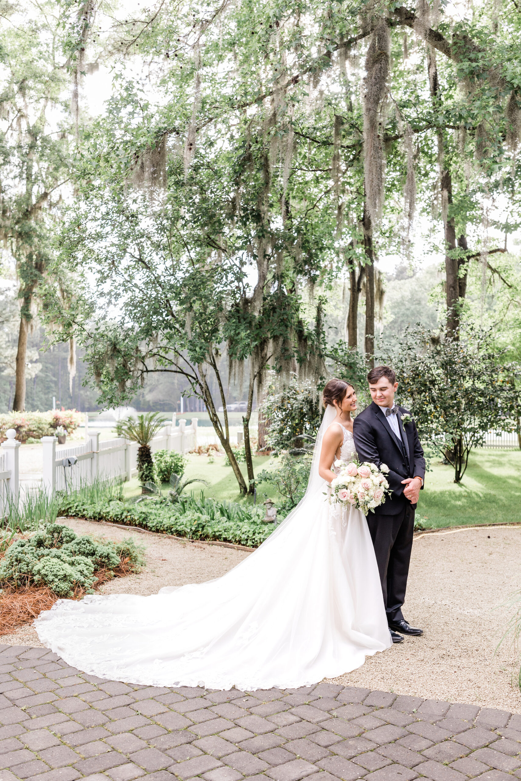 bride and groom full body portrait under sunny oak trees at the mackey house. Bright and airy Savannah, GA wedding photography. Taylor Brown Photography