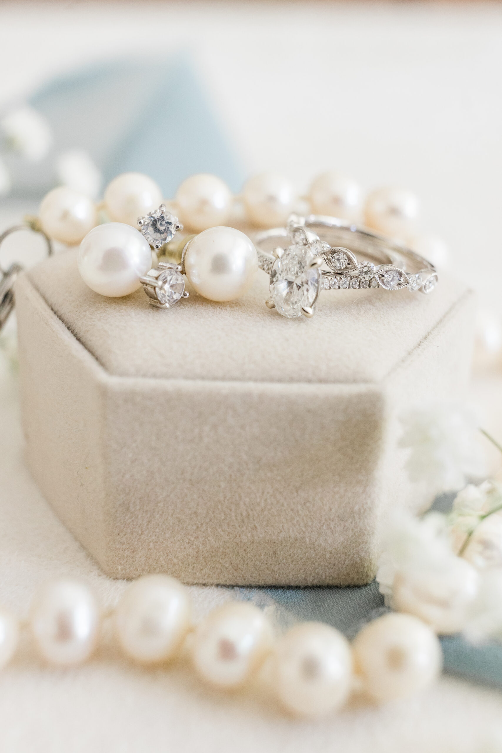 A box of pearls and a wedding ring on a table.